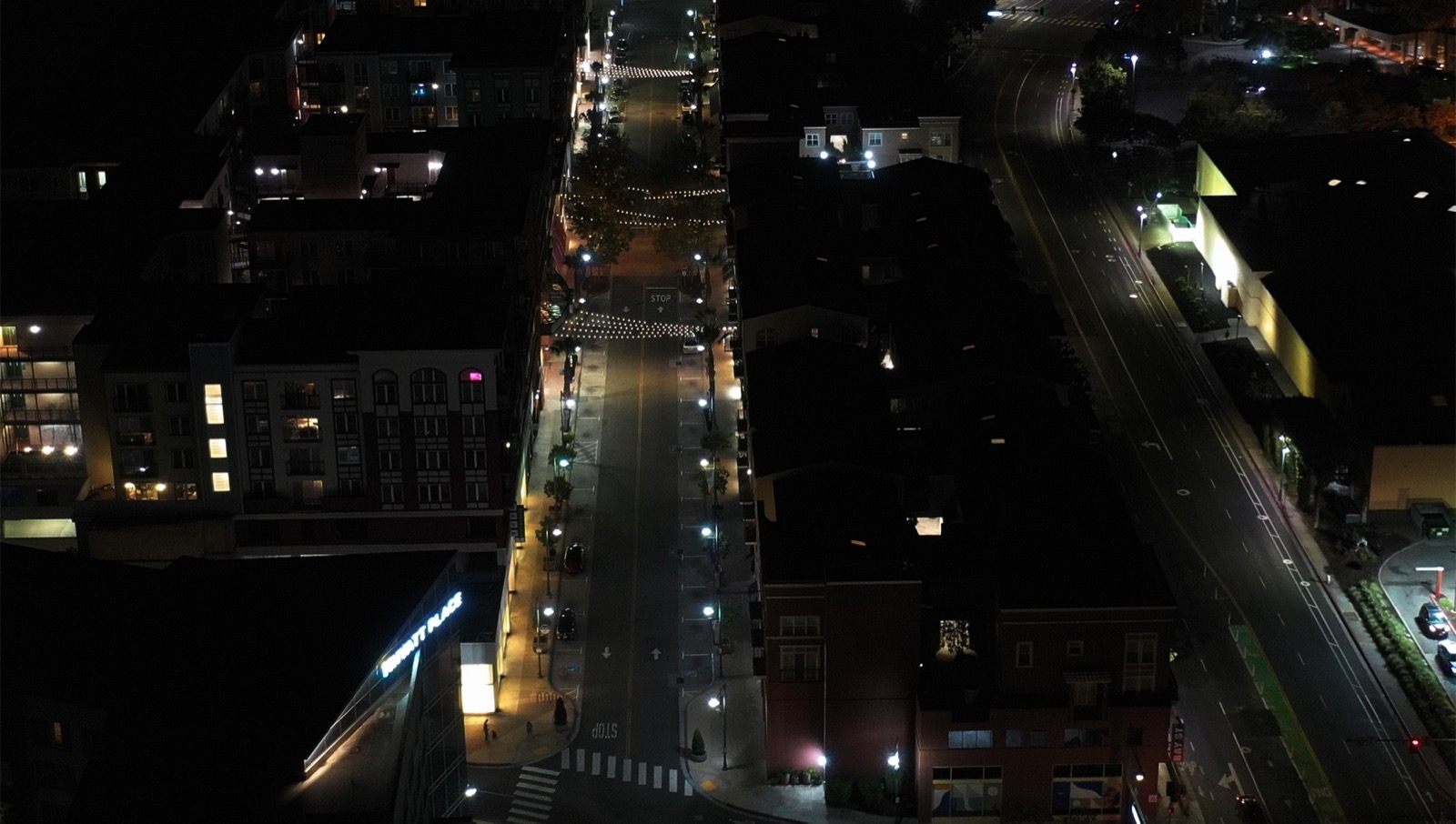 Main street at night before upgrade — dim pole lighting and dark sidewalks