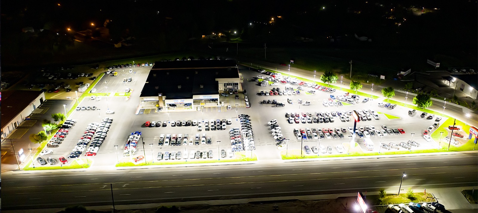 The same dealership lot after R9 upgrade — bright, uniform light across every row