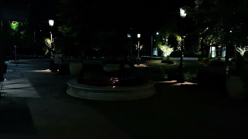 Plaza at night before retrofit — walkways dark and uninviting