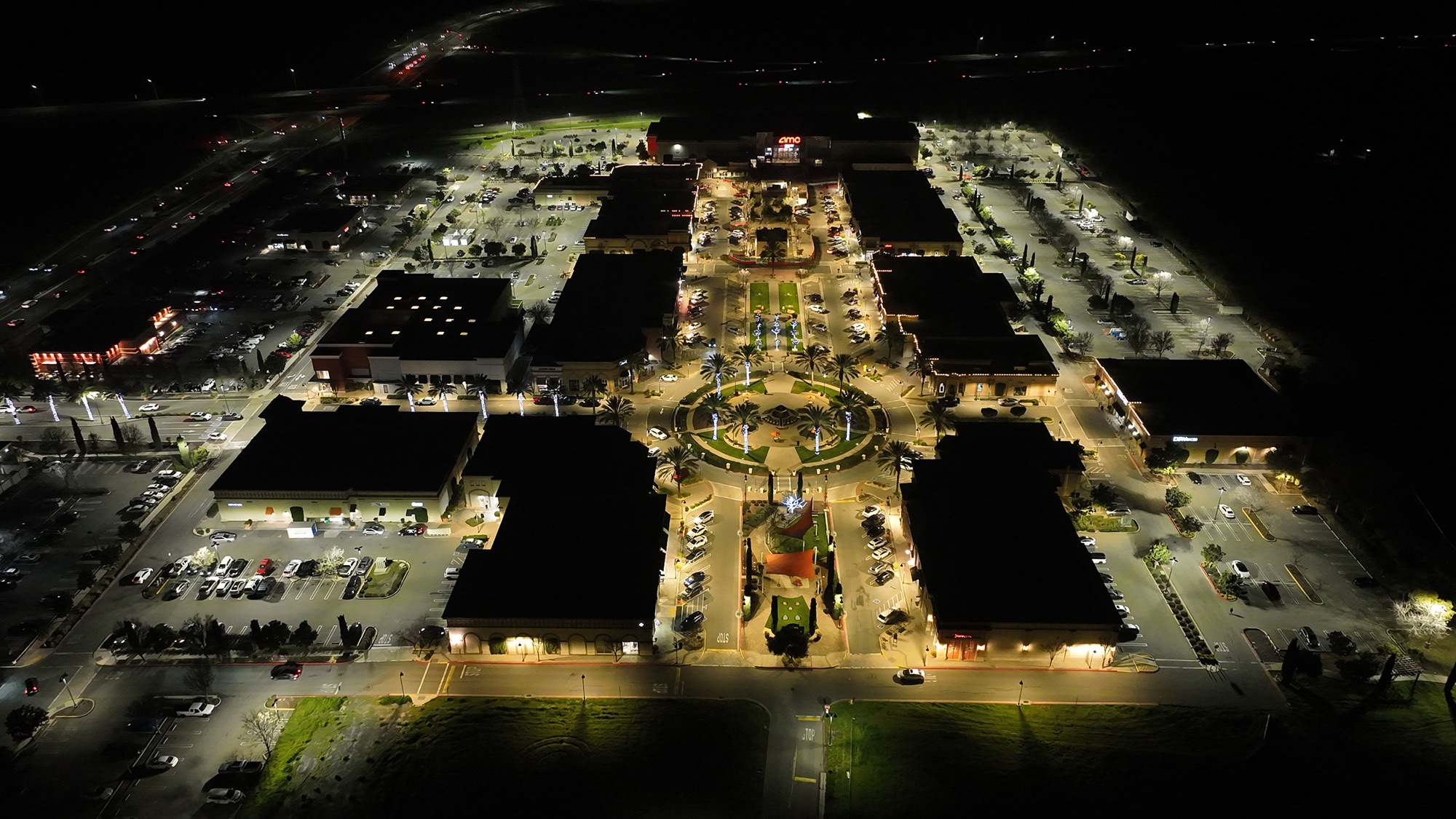 Aerial of Streets of Brentwood at night — R9 parking lot lighting, bright and even across every lot