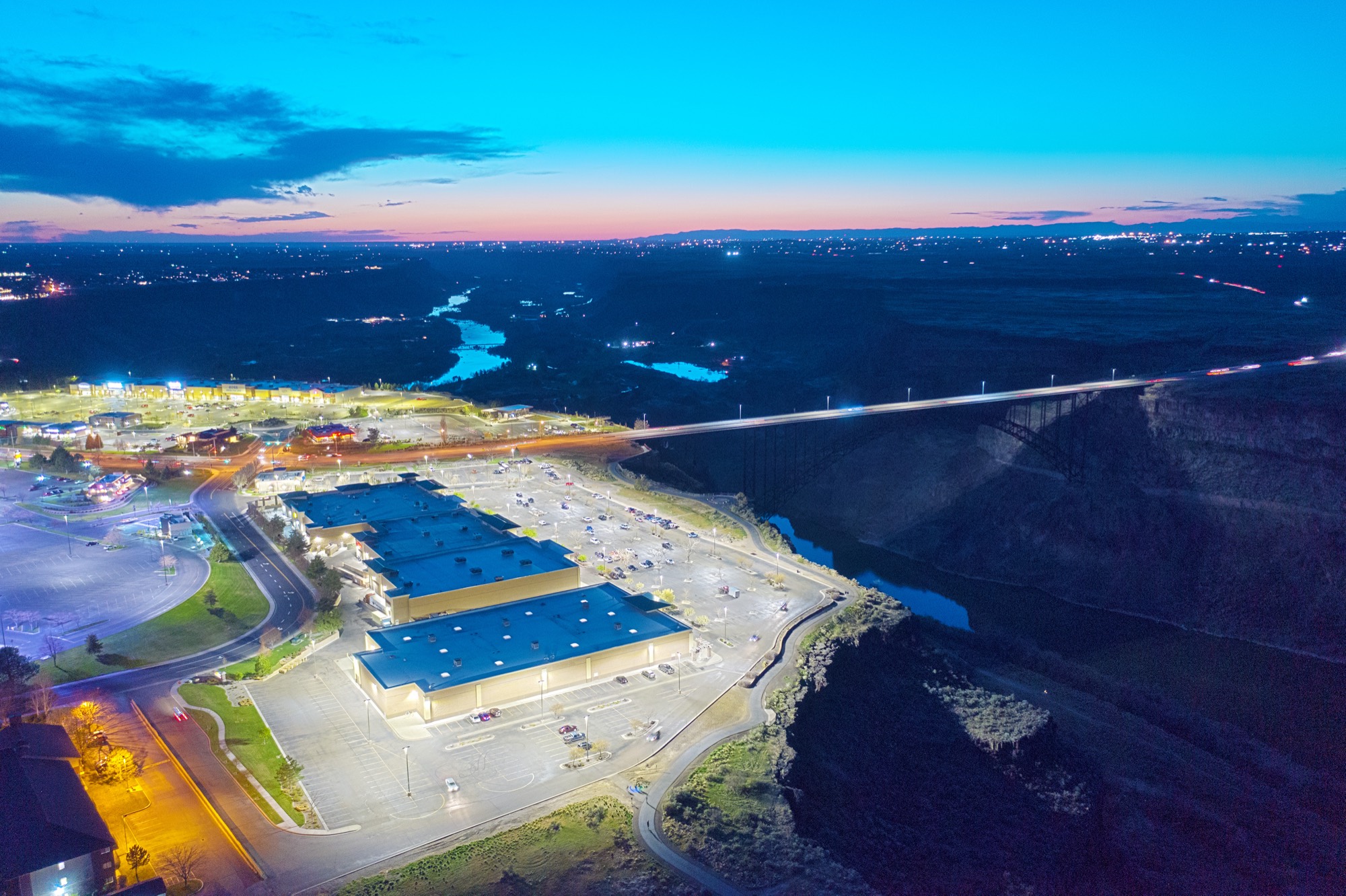 Dusk aerial of Canyon Park East above the Snake River canyon — R9 parking lot lighting, even light to the canyon rim