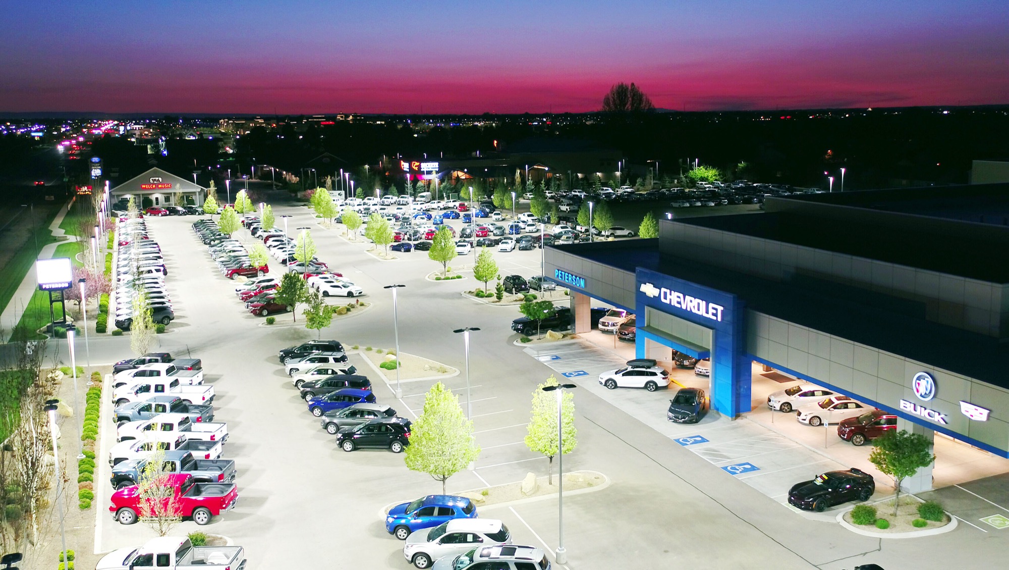Peterson Chevrolet dealership at sunset — R9 lot lighting rendering every vehicle bright and true-color