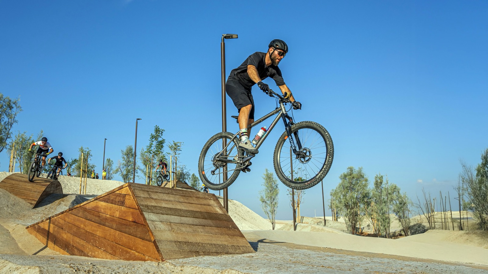 Rider mid-air at Trail X with an R9 light pole in frame
